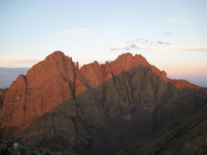 A stunning view of Crestone Needle (left) and Crestone Peak (right), with morning alpenglow above the shadow of Humboldt Peak.