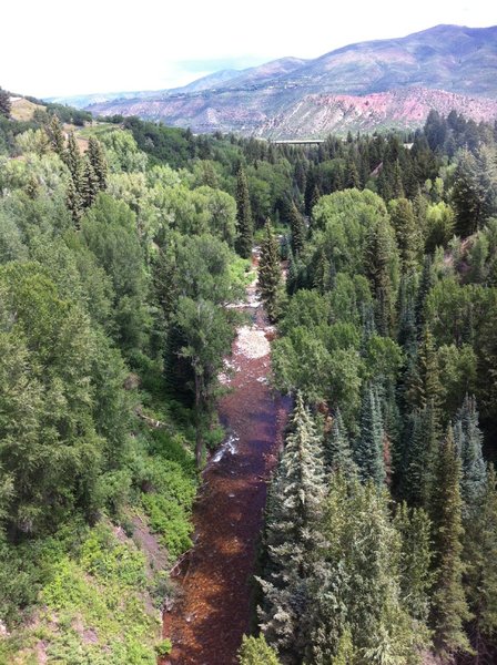 From Tiehack Bridge, Maroon Creek trail is hidden in the trees to the left of the Creek. Maroon Creek trail ends after a short climb just beyond the Highway 82 bridge in the distance.