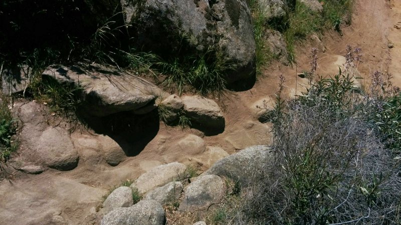 Technical area featuring large rocks and loose dirt.