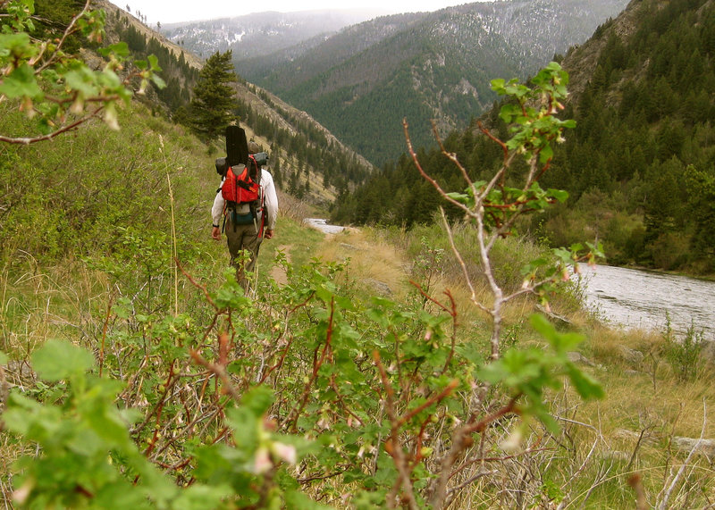 Hiking up Bear Trap Canyon Trail with a packraft.