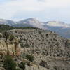 Looking back at the trail clinging to the slope and beyond to the Bookcliff Mountains