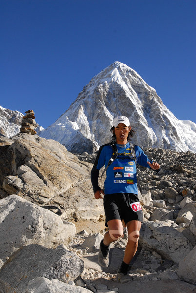 An elite runner making their way down a tight section of singletrack.