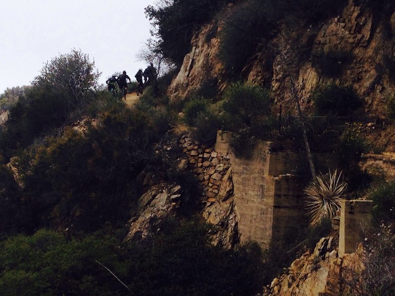 Mountain bikers headed toward the Mt. Lowe fire road with historic cog railroad foundations visible.