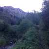 A view from the trail of the creek and a band of multicolored cliffs