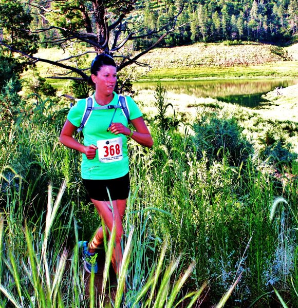 A happy runner enters the trail by the information kiosk.