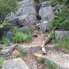 The trail pinches in between rocks.