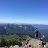 Hiker looking out from Panorama Point while cresting the Skyline Trail. Mount St. Helens looms in the distance.