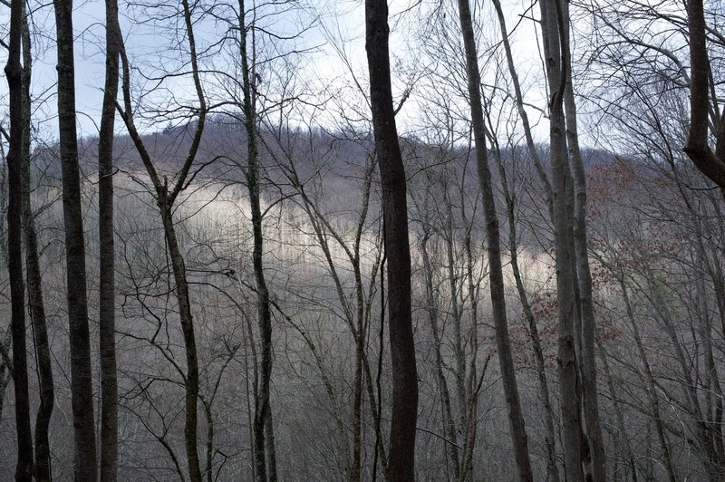 Sun breaking through the clouds and lighting up the mountain side.