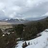 A stormy sky over the mountains and a snowy Wellington Ditch Trail.