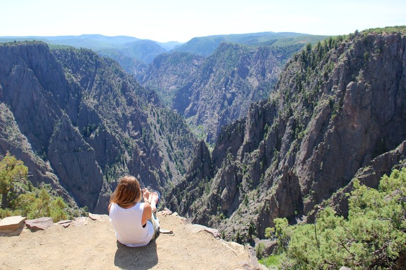 A woman relaxes at the first overlook on the Rim Rock Trail.