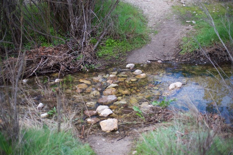 The creek crossing in the winter when water is running downstream.