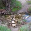 The creek crossing in the winter when water is running downstream.