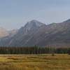 A view up Rogers Meadow as Camas Creek snakes through it. Mountains visible are right to left Stanton Mountain, Mt. Vaught, and Heavens Peak.