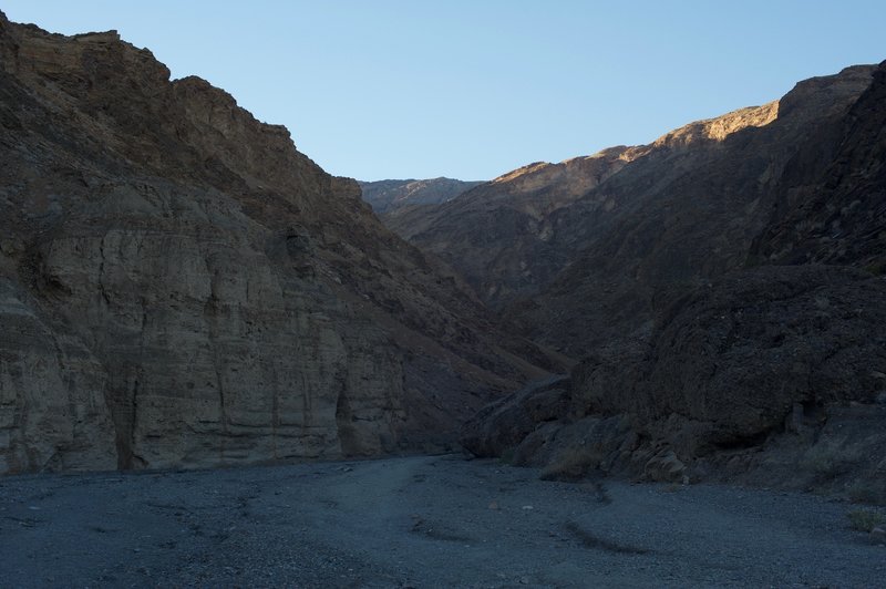 The sun creeps its way along the top of the surrounding hills and mountains, while the canyon stays shaded until later in the day.
