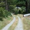 The trail becomes a two gravel tire tracks after the bridge.