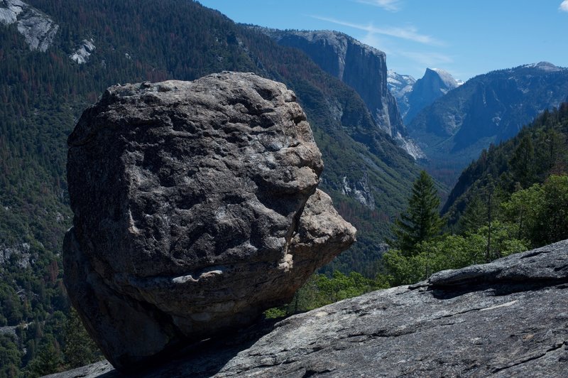 A glacial erratic with El Capitan and Half Dome in the background.