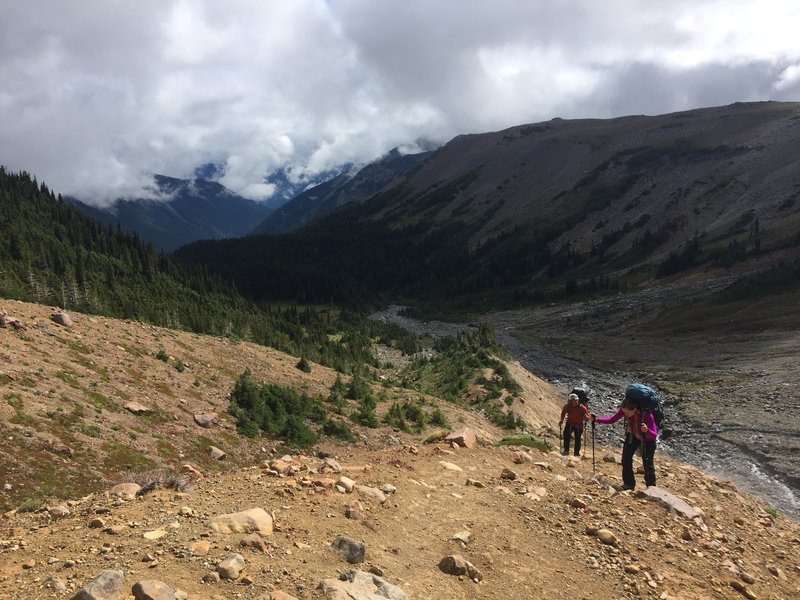 Climbers ascending while looking back on Glacier Basin Campground (near green clearing in photo).