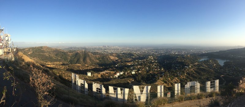 Standing above the Hollywood Sign with the city in the background.