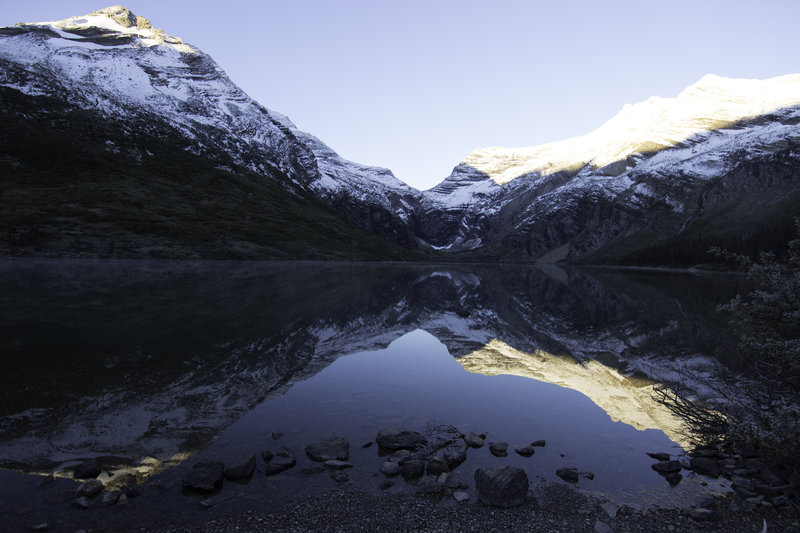 The sun rising over Gunsight Lake on a chilly morning.