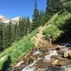 Crossing a waterfall heading up the trail.