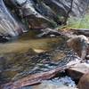 The pool below the falls before it crosses under the bridge.