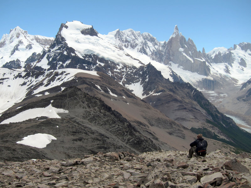 An adventurer enjoys the view from the summit of Loma del Pliegue Tumbado.