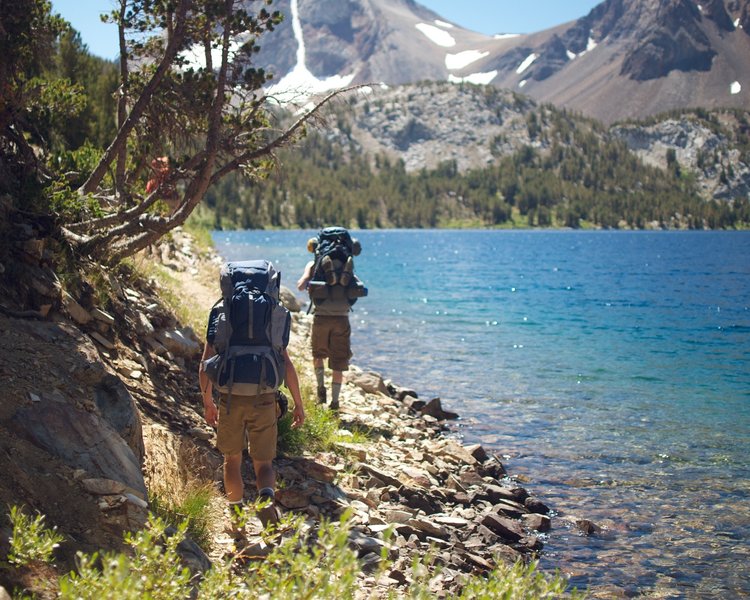 A pair of hikers navigates the spectacular shoreline of Lake Dorothy on the Bighorn Lake Trail.