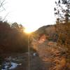 A woman and her dog head west from Bridal Veil Falls chasing the sunset.