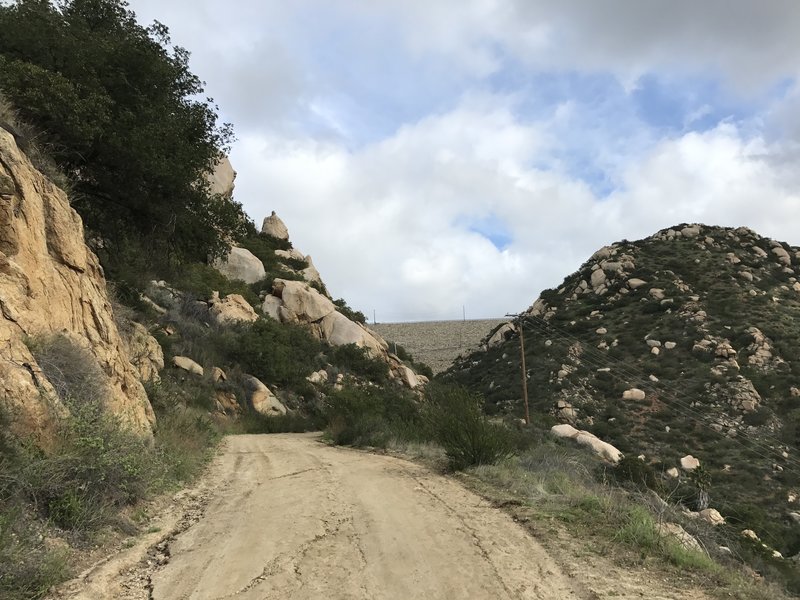 The Green Valley Truck Trail approaches the bottom of the dam along boulder-strewn cliffs.