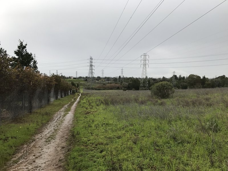 The trail follows the fence line of the cemetery and power lines leading to a PG&E substation.