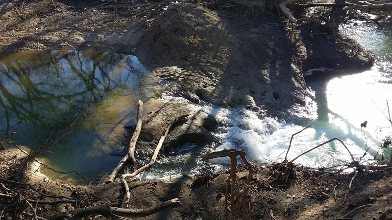 Rushing water flows past this creek intersection.