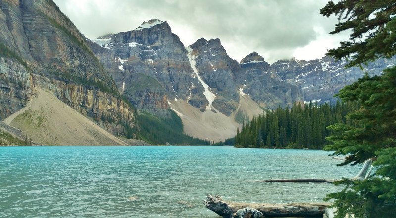 Moraine Lake is nestled within the Valley of Ten Peaks. Left-to-right is the base of the Tower of Babel, Mt. Babel, Mt. Fay, Tonsa Peak, and Mt. Allen (in a cloud).