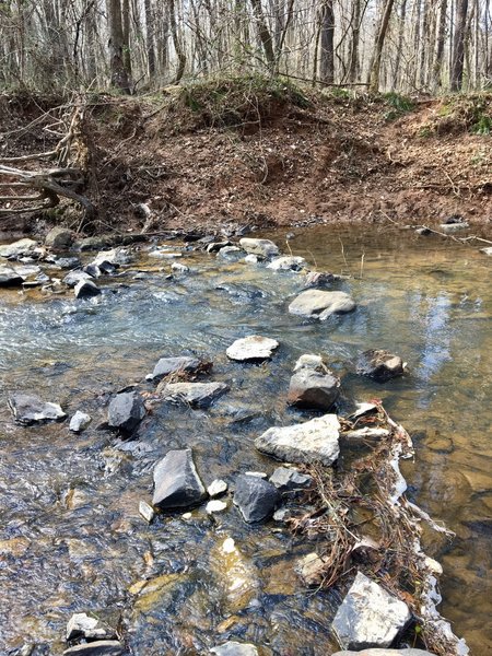 Take care in placing your feet as you navigate this creek crossing along the trail.