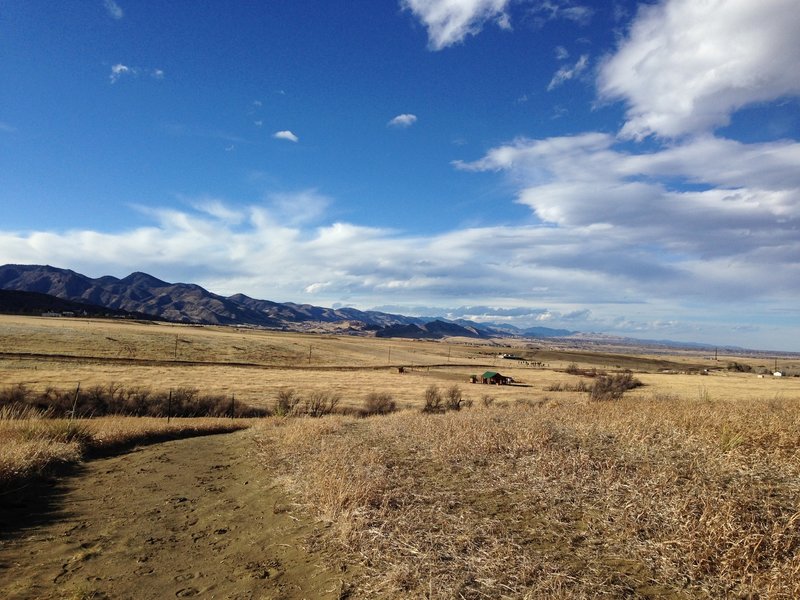 Looking north from the Sharptail Ridge Trail, you'll see phenomenal views of the Front Range. The trailhead barn can be seen below (with a green roof).