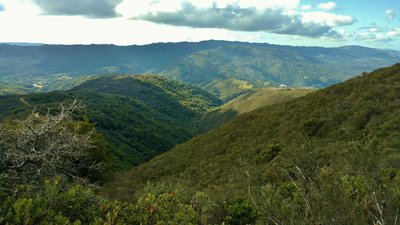 Hills and the Santa Cruz Mountains stand on the far side of Lexington Reservoir in the distance. The Priest Rock Trail meanders along a ridge-top on the left. This is looking west from near the top of the Priest Rock Trail.