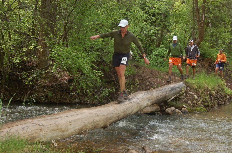 Runners navigate a log crossing of the Left Fork Hobble Creek at about mile 28 of the Squaw Peak 50 Mile Trail Run.