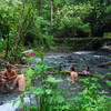 Friends soak in the natural hot springs near Tabacon.