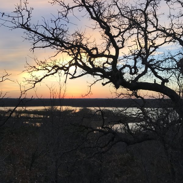 The sun rises over Lake Mineral Wells State Park from the Cross Timbers Black Trail.