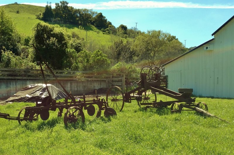 Old ranch machinery stands outside the historic ranch house and grounds.