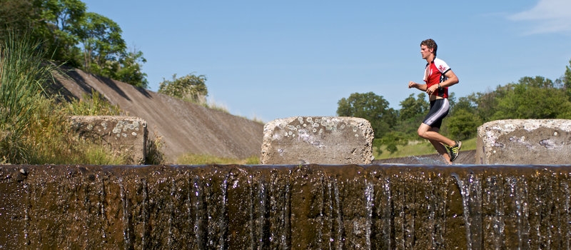 An athlete charges through the spillway canal that characterizes the Meadowlark Trail.