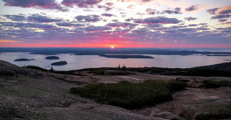 The sun rises over Cadillac Mountain and the archipelago.