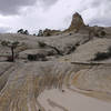 A hiker ascends a slickrock ridge on the Boulder Mail Trail.