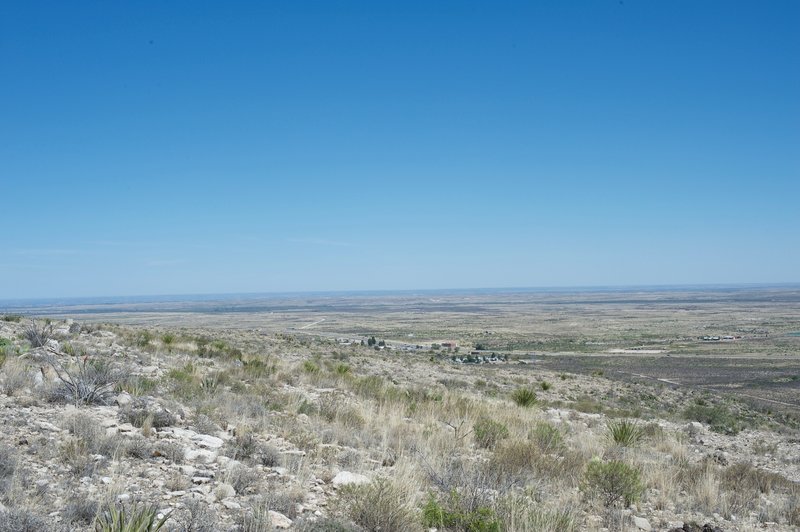 The first glimpse of Whites City comes into view while the New Mexico landscape stretches out beyond.