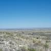 The first glimpse of Whites City comes into view while the New Mexico landscape stretches out beyond.