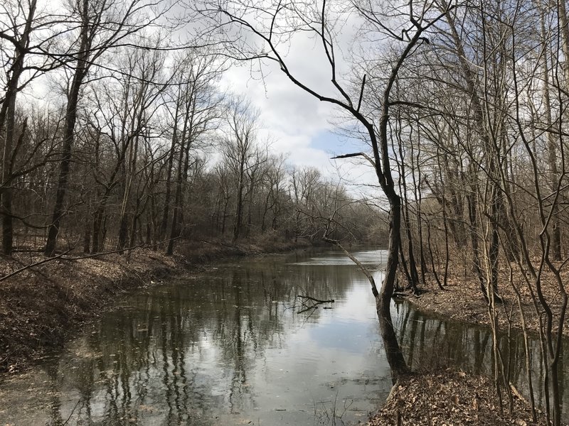 The trail crosses a small, peaceful pond.