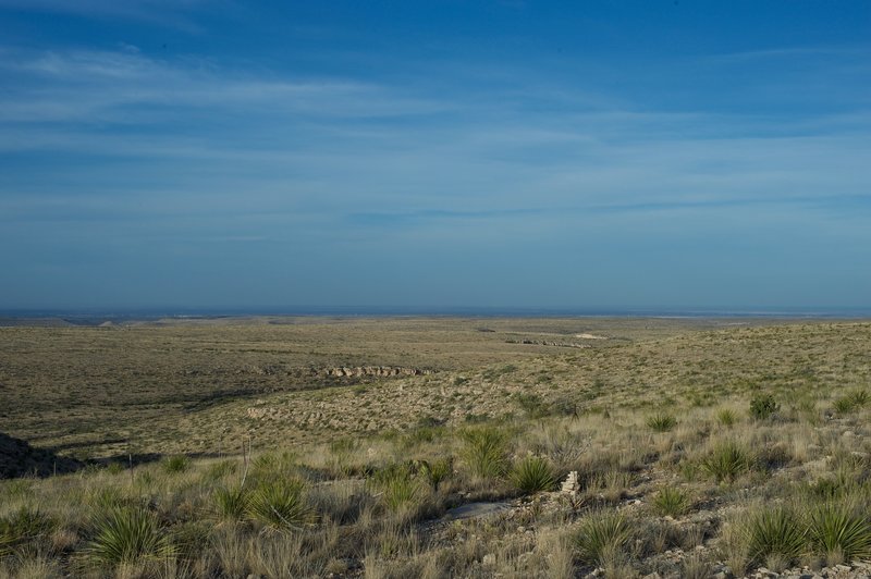 When the trail crests the ridge, views of the desert spread out before you. You can see the park boundary fence and cairns that mark the trail.