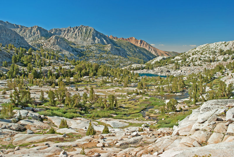 Looking across Middle Fork Basin towards Piute Crags (orange) with Topsy Turvy Lake in the distance.