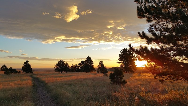 A lovely sunrise, heading east on the trail. Wear a hat with a brim! September 2015.