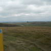 The yellow NCT Carsonite marker in the foreground, with swaths of virgin prairie in the background.