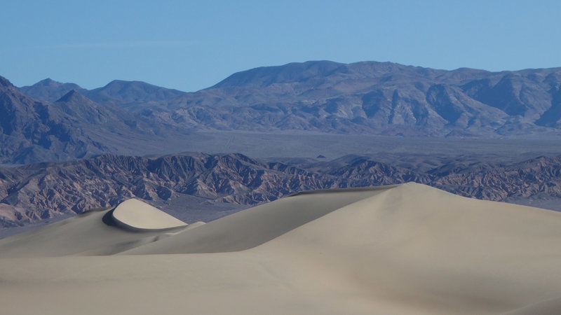 Crescent dunes are framed by the mountains to the west.